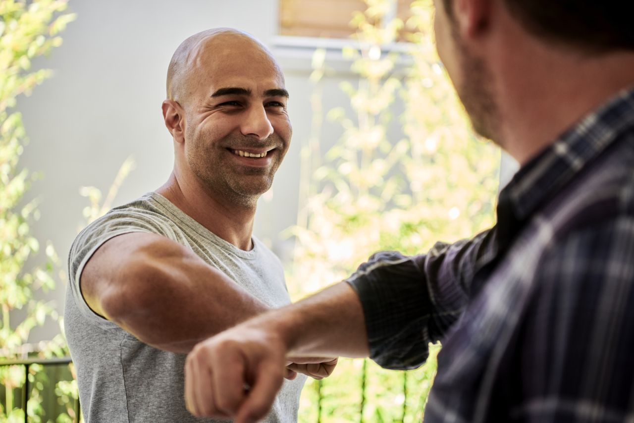 two men elbow bumping