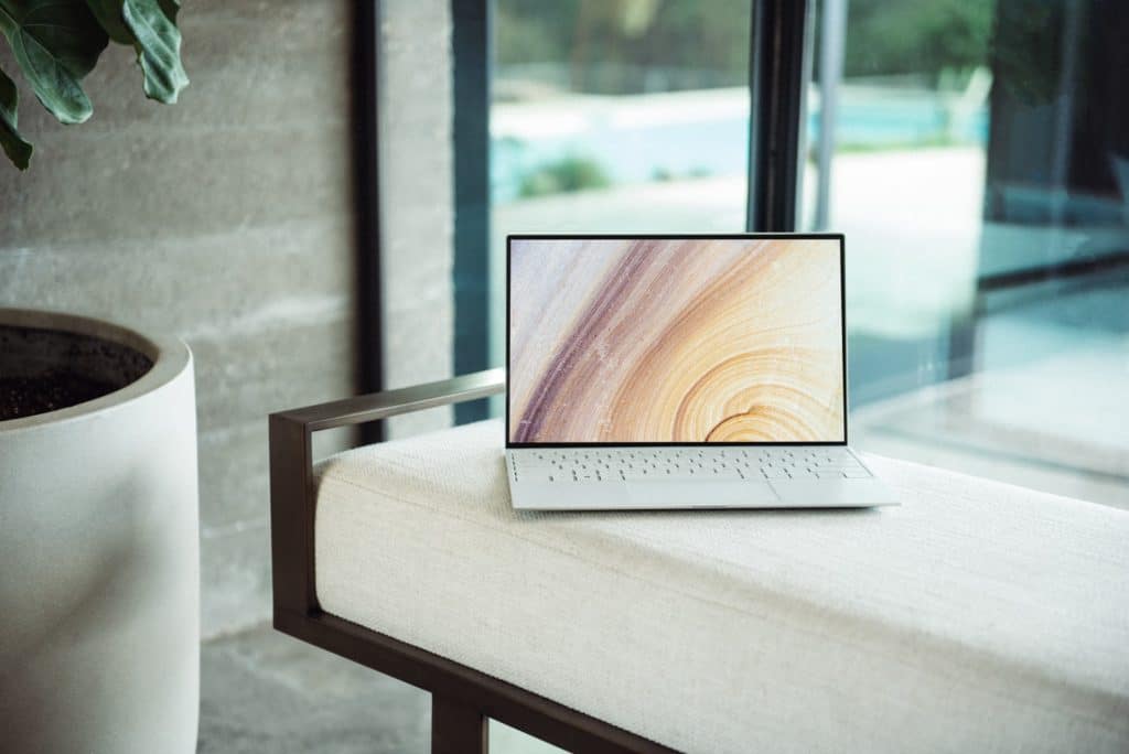 ordinateur portable argenté sur une table en bois brun